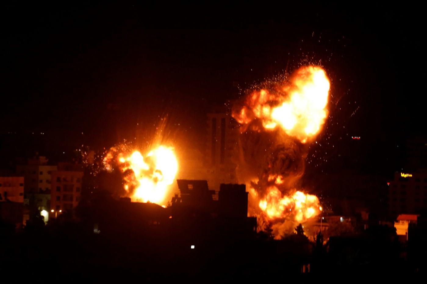 Boules de feu au-dessus d’une zone urbaine la nuit à Gaza.