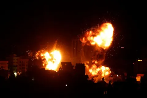 Boules de feu au-dessus d’une zone urbaine la nuit à Gaza.